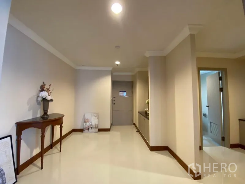 Condominium for rent in Watthana, Bangkok - Bright entry hallway with console table, cream walls and access to a bathroom.