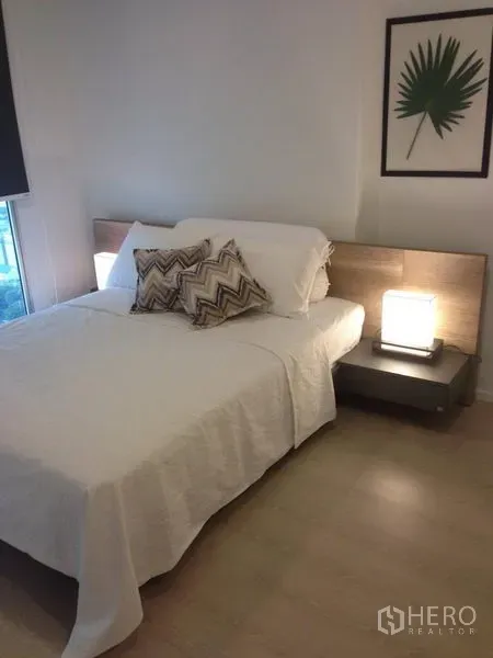 Condominium for rent in Sathon, Bangkok - Cozy bedroom with double bed, wood headboard and bedside lamps at Rhythm Sathorn.