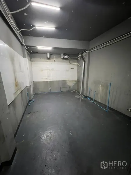 店屋 出租在Watthana, Bangkok - 带排风与外露管线的备餐间，灰墙与明亮灯条。