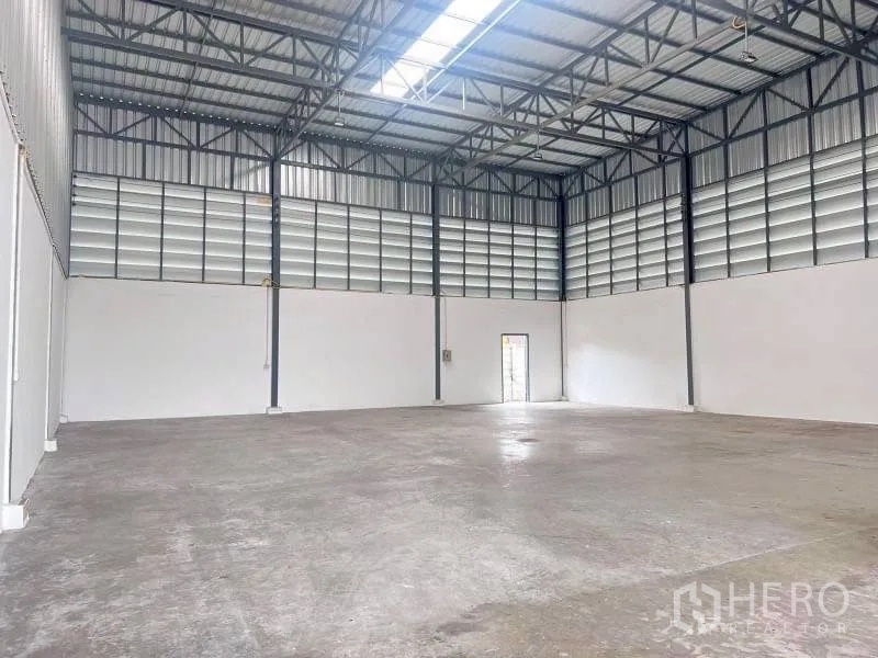 โกดัง for rent in Lam Luk Ka, Pathum Thani - ฮอลล์โกดังกว้างหลังคาเมทัลชีท พื้นคอนกรีต และประตูด้านข้าง