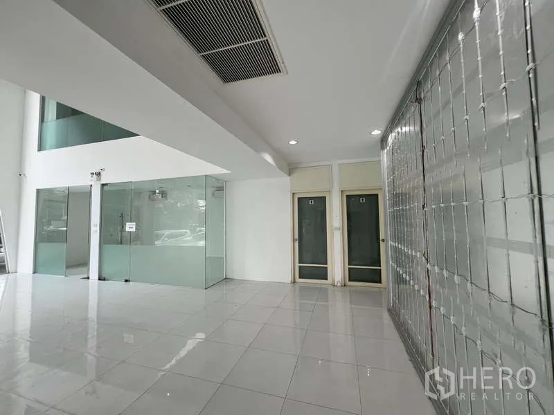 展厅 出租 - 一层大堂，玻璃隔间、瓷砖地面及卷闸安全门。