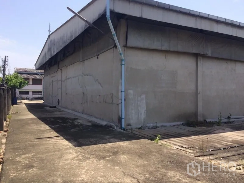 คลังสินค้า ให้เช่าในSamut Prakan - ด้านข้างอาคารโกดังพร้อมทางสัญจรแคบและท่อระบายน้ำ