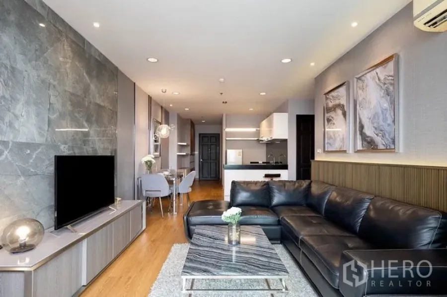 คอนโด ให้เช่าในPhaya Thai, Bangkok - ห้องนั่งเล่นสไตล์โมเดิร์น โซฟาหนังสีดำ ทีวี และโต๊ะกลางลายหินอ่อน