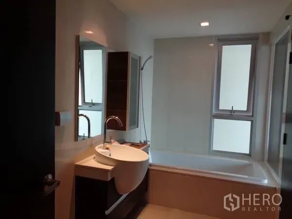 公寓 出租在Watthana, Bangkok - 现代浴室，浴缸、手持花洒和带窗的洗手台。