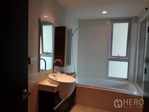 公寓 出租在Watthana, Bangkok - 现代浴室，浴缸、手持花洒和带窗的洗手台。