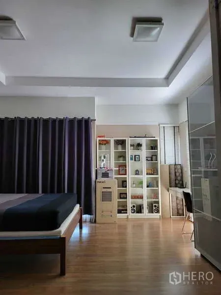 บ้าน ให้เช่าในLat Krabang, Bangkok - ห้องนอนสว่าง พร้อมเตียง ตู้หนังสือบานกระจก โต๊ะทำงานข้างหน้าต่าง และพื้นไม้