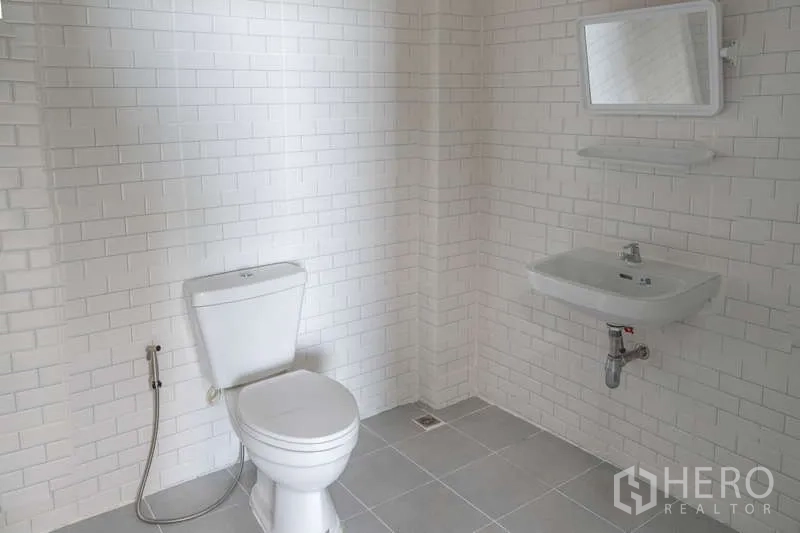 คลังสินค้า ให้เช่าในKhlong Luang, Pathum Thani - ห้องน้ำกระเบื้องสีขาวสะอาด มีโถสุขภัณฑ์ อ่างล้างหน้า และสายฉีด