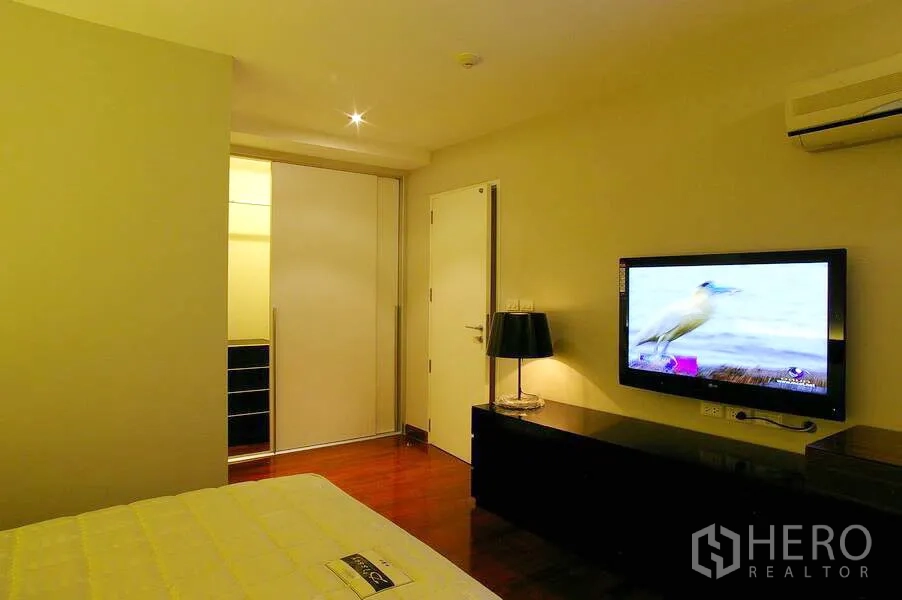 公寓 出租在Watthana, Bangkok - L形厨房，木纹橱柜、石材台面，嵌入式烤箱、灶台、水槽与冰箱。