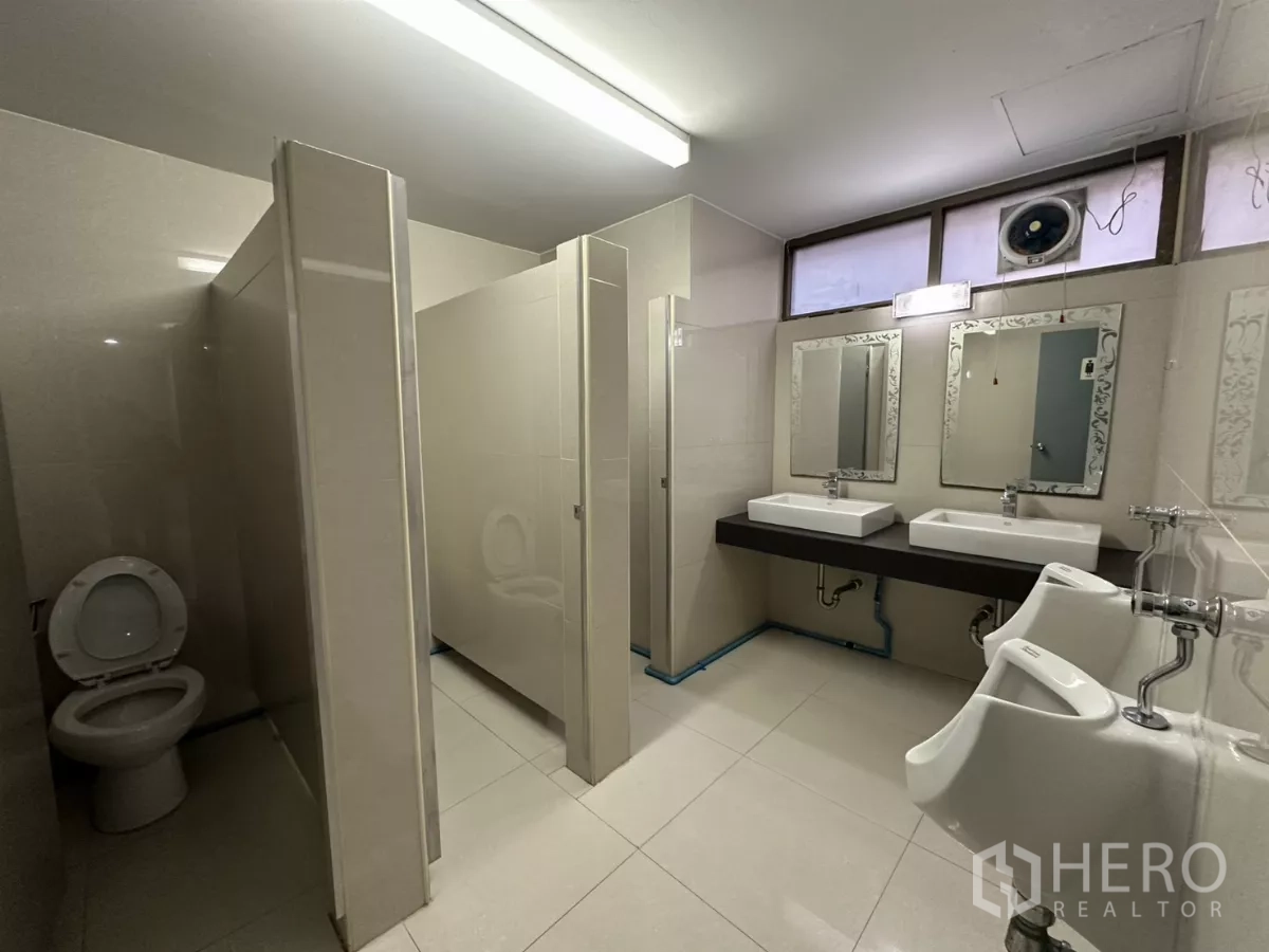 办公空间 出租 - 公共卫生间，隔间、小便斗、双洗手台与镜子。