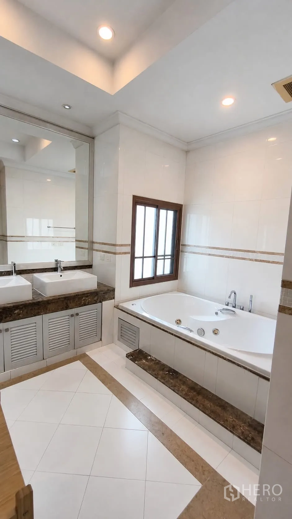 Detached House for rent in Watthana, Bangkok - Bathroom with double vanity, large built-in bathtub and window.