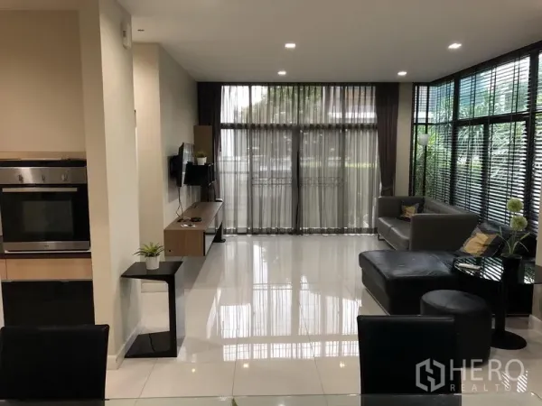 Detached House for rent in Bang Kapi, Bangkok - Bright open-plan living room with floor-to-ceiling windows and glossy tile floors.