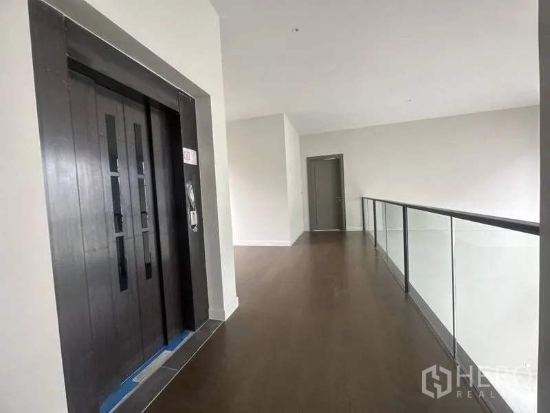 Detached House for rent - Second-floor corridor with private home elevator and long glass railing.