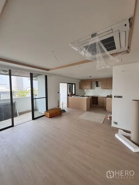 อพาร์ทเมนท์ ให้เช่าในKhlong Toei, Bangkok - โซนรับแขกเชื่อมครัว แอร์ฝังฝ้า และประตูกระจกบานเลื่อนออกไประเบียง ระหว่างตกแต่ง