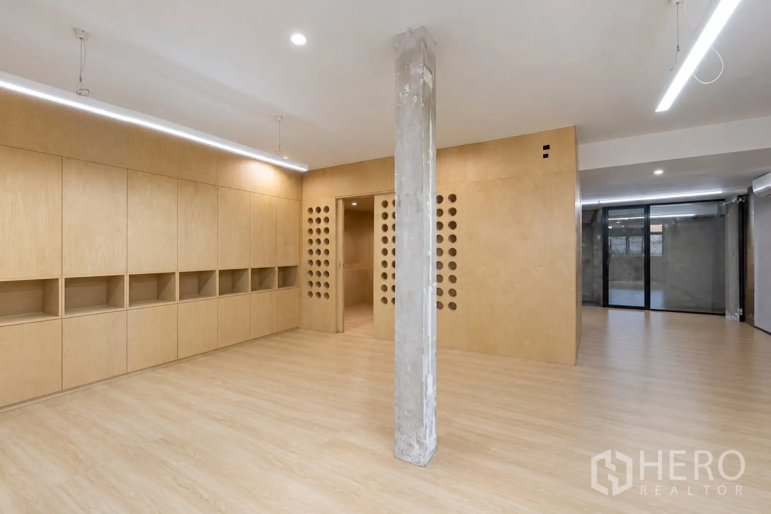 Retail Space for rent in Watthana, Bangkok - Open area with built-in wooden cabinetry, a central concrete column, and sliding door.