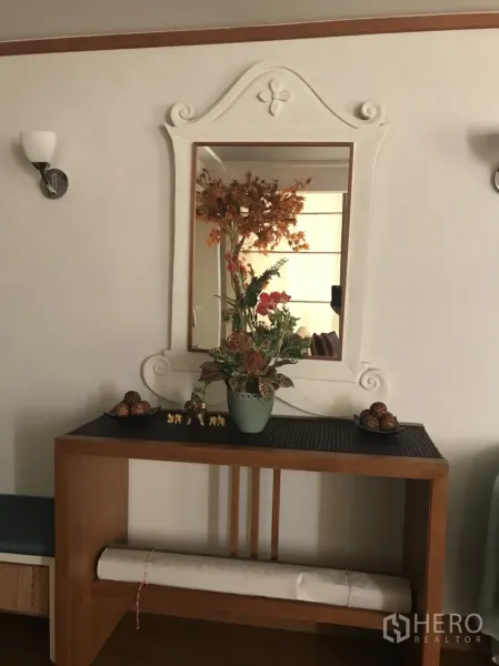 公寓 出租在Pathum Wan, Bangkok - 入口处木质玄关台、装饰镜与干花摆设的曼谷公寓一隅。