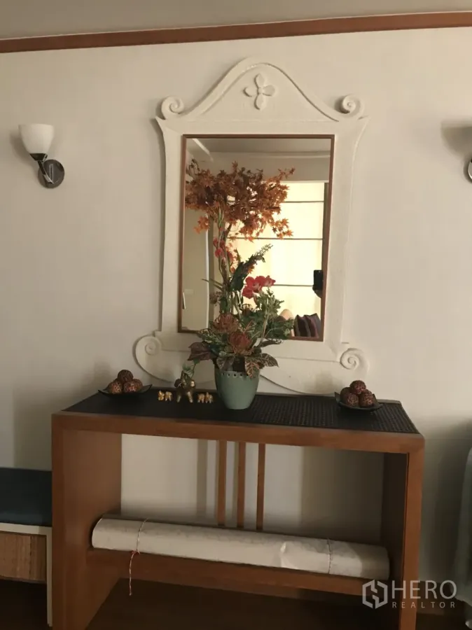 公寓 出租在Pathum Wan, Bangkok - 入口处木质玄关台、装饰镜与干花摆设的曼谷公寓一隅。