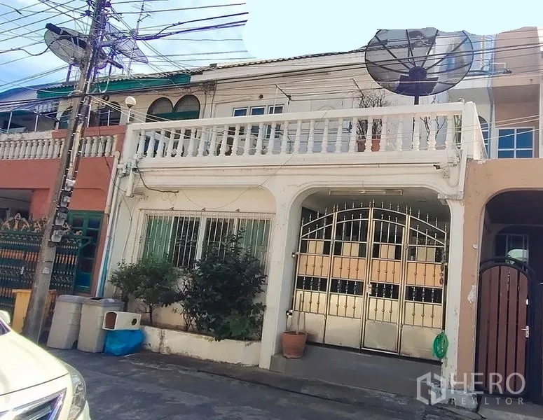 ทาวน์เฮาส์ ให้เช่าในWatthana, Bangkok - มุมมองหน้าบ้านทาวน์เฮ้าส์ระเบียงราวสีขาวและจานดาวเทียม