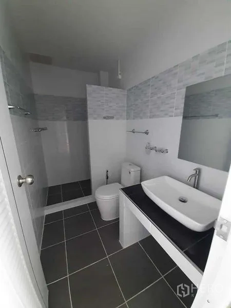 工厂 出租或出售 - 整洁卫浴，台上盆与淋浴区，灰色瓷砖。