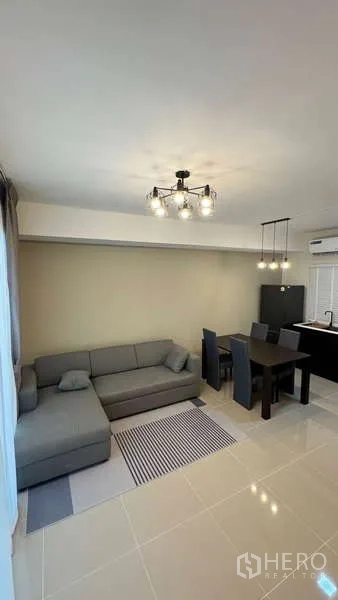Townhouse for rent in Bang Phli, Samut Prakan - Open-plan lounge and dining zone with pendant lighting and tiled floor.