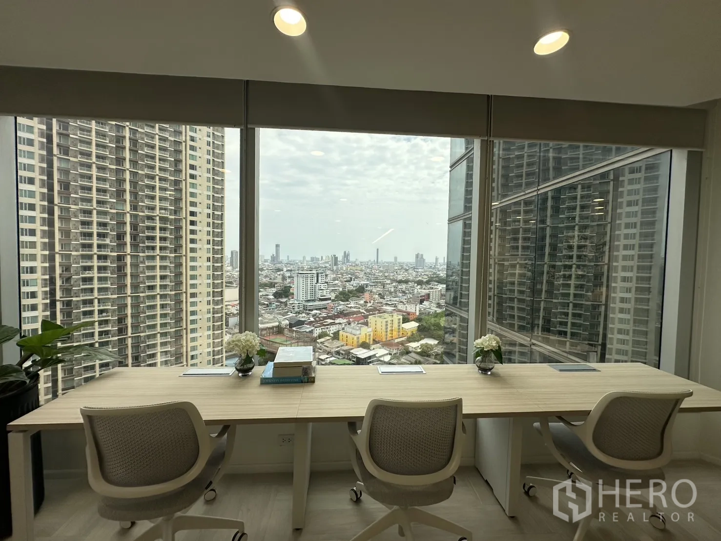 Office Space for rent in Sathon, Bangkok - Desks beside panoramic windows overlooking the Bangkok skyline and nearby high-rise towers.