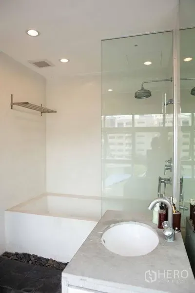 联排别墅 出售 - 明亮浴室，玻璃淋浴间、深泡浴缸与石质台盆。