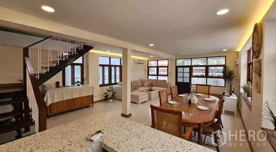 บ้าน ให้เช่าในKhlong Toei, Bangkok - โถงนั่งเล่นและรับประทานอาหารแบบโอเพนแพลน มีบันได โคมดาวน์ไลท์ และหน้าต่างบานใหญ่