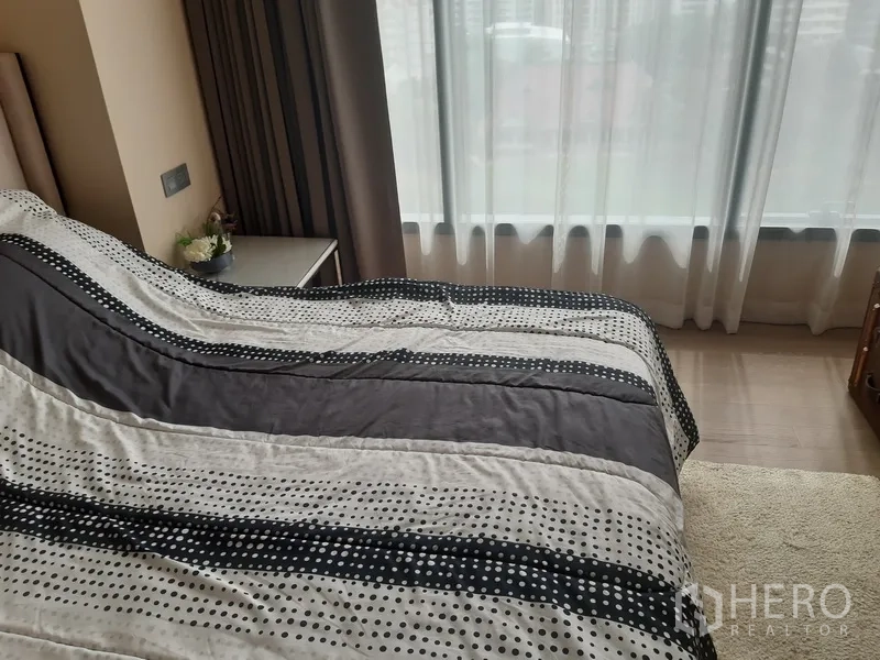 คอนโด ให้เช่าหรือขายในWatthana, Bangkok - ห้องนอนอบอุ่น ผ้าปูเตียงลายทาง และหน้าต่างสูงจรดเพดานพร้อมผ้าม่านบาง