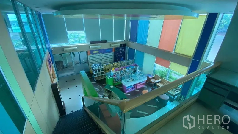 Office Space for sale in Bang Kapi, Bangkok - Double-height lobby with colorful blinds, staircase and a reception or showroom-style display area.