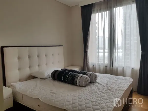 คอนโด ให้เช่าในRatchathewi, Bangkok - ห้องนอนอบอุ่นพร้อมหัวเตียงบุหนัง หน้าต่างบานใหญ่และผ้าม่านโปร่ง มองเห็นวิวเมือง