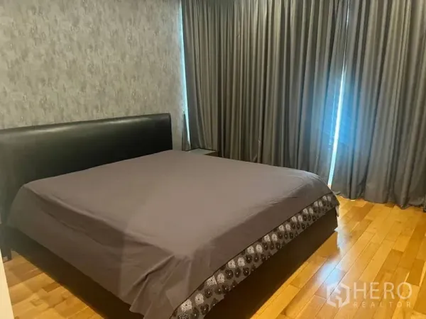 คอนโด ให้เช่าในBangkok - ห้องนอนใหญ่พื้นไม้พร้อมเตียงคิงไซซ์และผ้าม่านทึบสูงจรดเพดาน