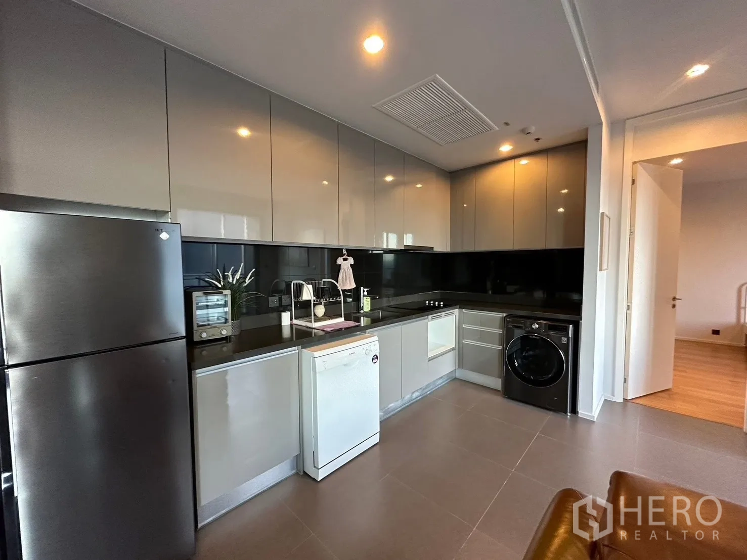 คอนโด for rent or sale in Chatuchak, Bangkok - ครัวทันสมัยตู้บานเงา พร้อมตู้เย็น เครื่องล้างจาน และเครื่องซักผ้า