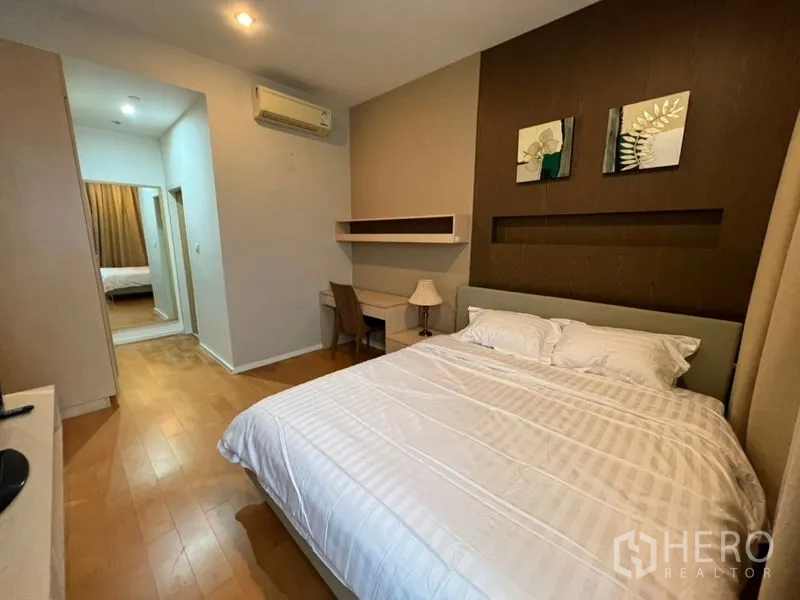 คอนโด ให้เช่าในChatuchak, Bangkok - ห้องนอนพร้อมเตียงควีน ชั้นวางติดผนัง แอร์ และพื้นไม้โทนอุ่น