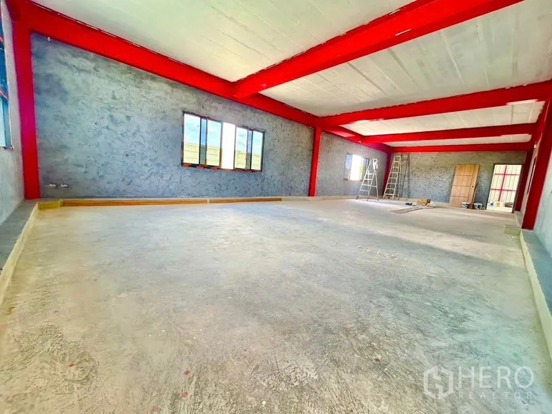 货栈 出租在Lam Luk Ka, Pathum Thani - 仓库内未完工的夹层办公区，配窗户与红色梁柱。