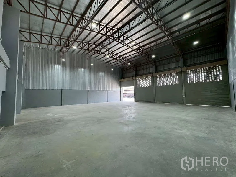 货栈 出租在Bang Phli, Samut Prakan - 开阔仓库空间，钢架屋顶与卷闸装卸门