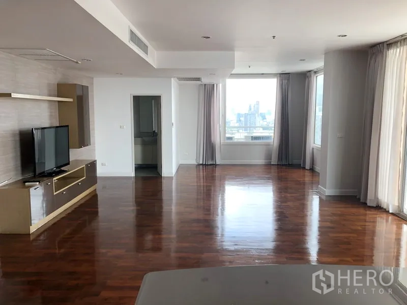 คอนโด ให้เช่าในKhlong Toei, Bangkok - ห้องนั่งเล่นกว้าง พื้นไม้เงา หน้าต่างบานใหญ่ พร้อมชั้นวางทีวีและวิวเมือง