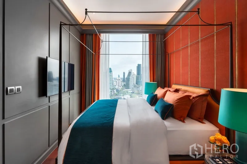 Condominium for sale in Watthana, Bangkok - Side view of the bedroom with a large window framing the Bangkok skyline.