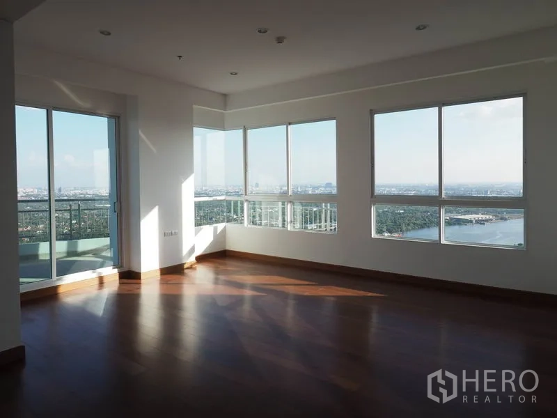 Condominium for rent or sale in Yan Nawa, Bangkok - Corner lounge with wraparound windows overlooking river and skyline.