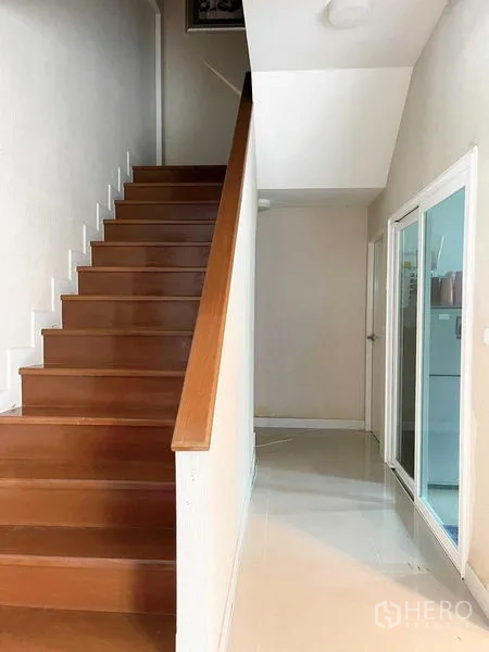 บ้าน ขายในBang Phli, Samut Prakan - โถงทางเดินสว่าง บันไดไม้ พื้นกระเบื้อง และประตูกระจกบานเลื่อน ภายในบ้านเดี่ยว