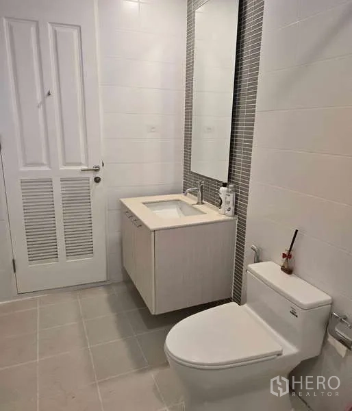 Townhouse for sale in Watthana, Bangkok - Clean bathroom with vanity, mirror and toilet.