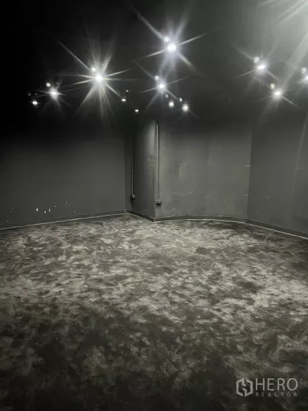 Home Office for rent in Wang Thonglang, Bangkok - Large soundproofed room with black carpet and ceiling spotlights, ideal for studio use.