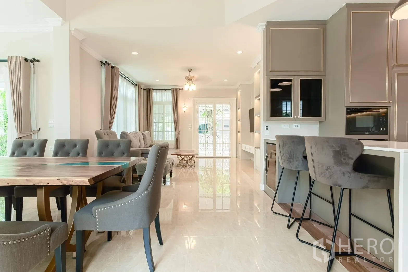 Detached House for rent in Bang Na, Bangkok - Open-plan lounge and dining with bar stools and full-height curtains.