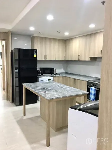 公寓 出租在Watthana, Bangkok - 浅木色橱柜的开放式厨房，花岗岩中岛与大号冰箱