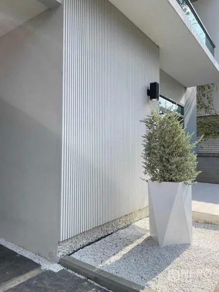 บ้าน ขายในNuea Khlong, Krabi - มุมผนังภายนอกลายเซาะร่อง มีไฟติดผนังและกระถางต้นไม้ทรงเรขาคณิต