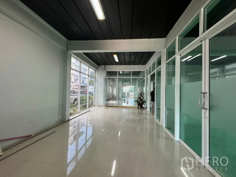 Warehouse for rent or sale in Chon Buri - Entrance lobby with floor-to-ceiling glass storefront and corridor to offices.
