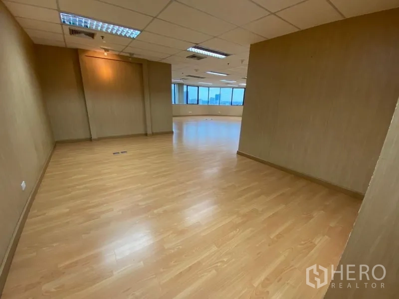 Office Space for rent in Watthana, Bangkok - Corridor leading to the main open office with wood flooring and suspended ceiling lighting.