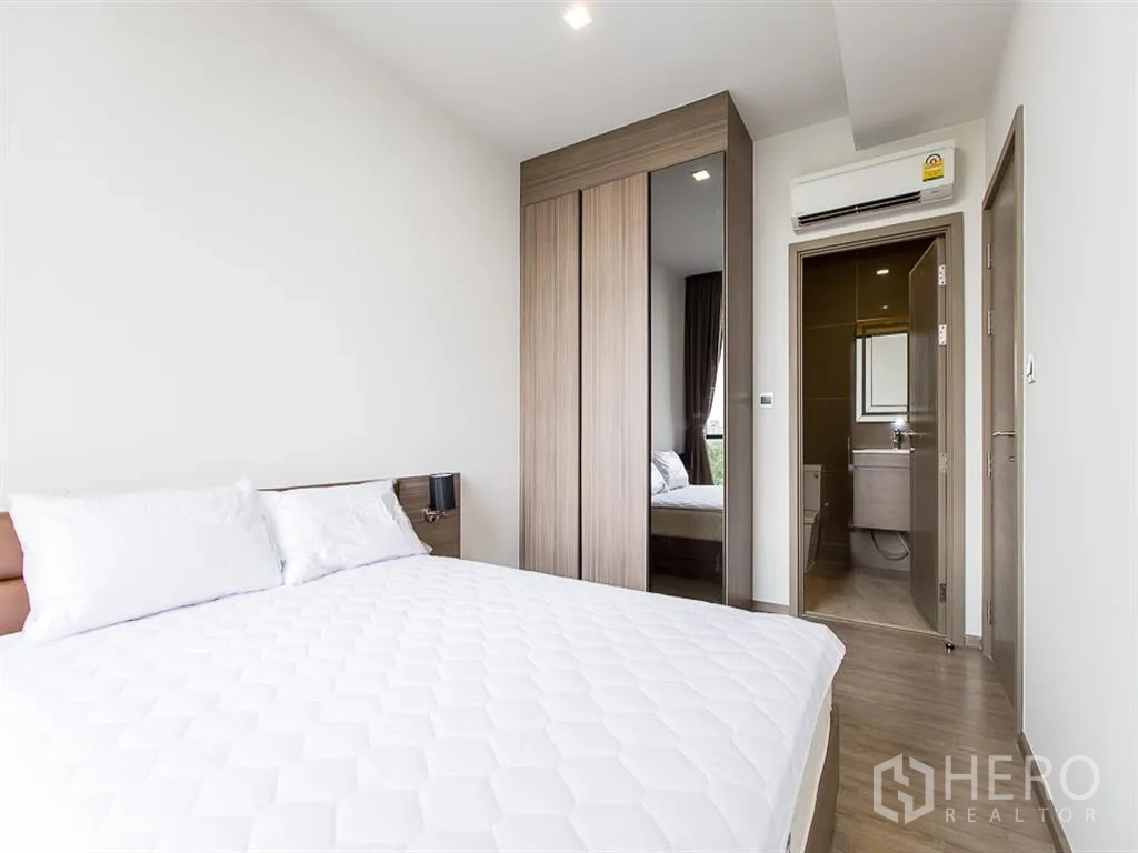 คอนโด for rent in Watthana, Bangkok - ห้องนอนมีตู้เสื้อผ้าบานกระจก เครื่องปรับอากาศ และประตูเข้าห้องน้ำ