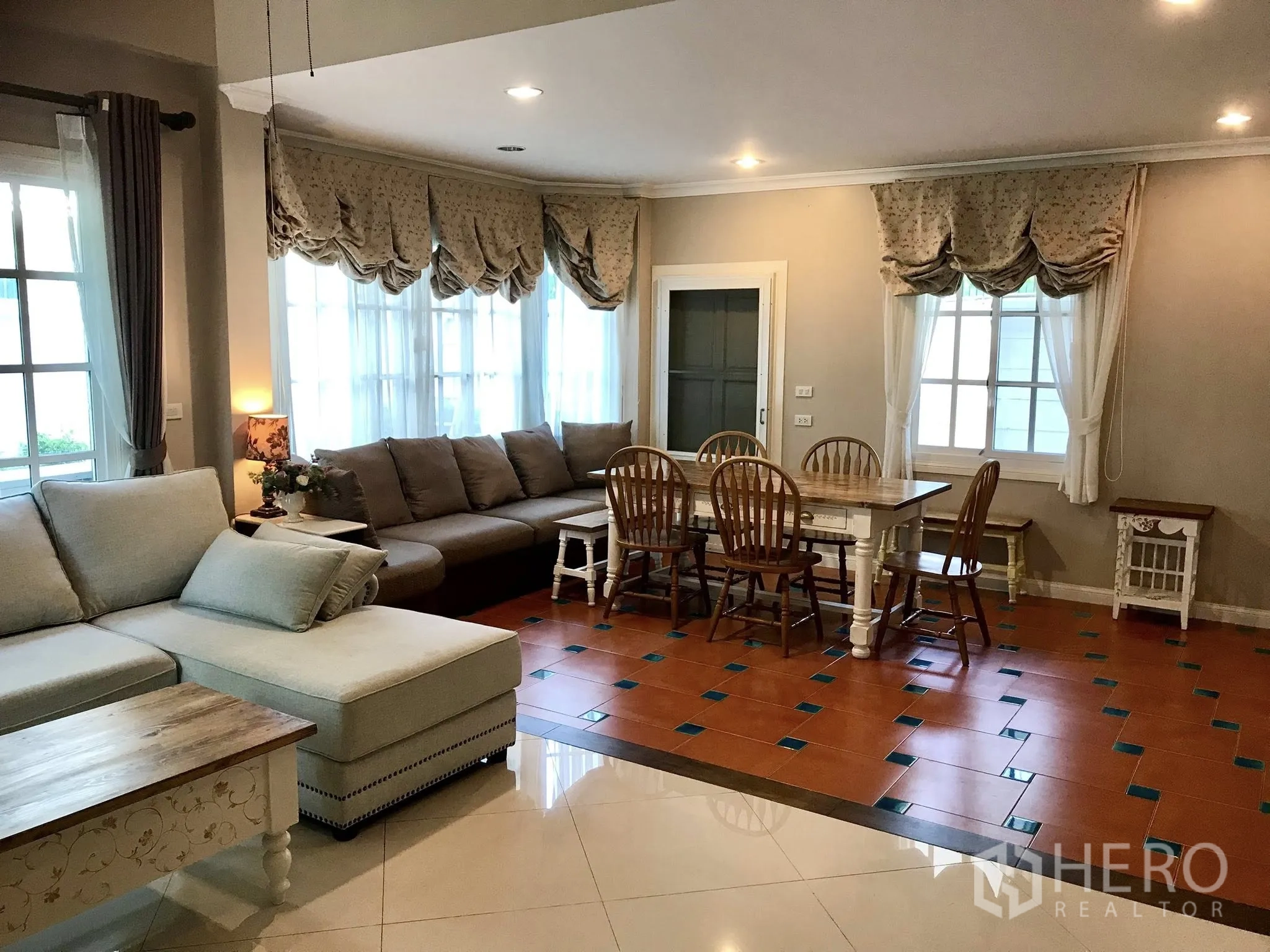 Detached House for rent in Mueang Samut Prakan, Samut Prakan - Open-plan living and dining space with sectional sofa and six-seat table.