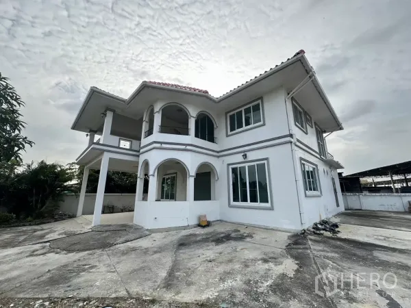 สำนักงานที่บ้าน ให้เช่า - มุมอาคารสีขาวโชว์ระเบียงโค้งและหน้าต่างบานใหญ่.