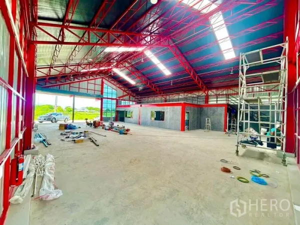 货栈 出租在Lam Luk Ka, Pathum Thani - 开放式仓库地面，红色梁架与天窗，带可用作夹层的办公区。