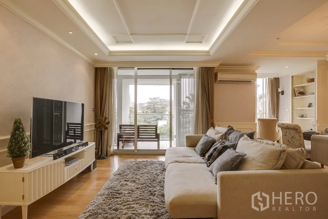 คอนโด ให้เช่าหรือขายในWatthana, Bangkok - ห้องนั่งเล่นสว่างด้วยโซฟาขนาดใหญ่ ตู้ทีวี และประตูกระจกบานเลื่อนออกสู่ระเบียงวิวต้นไม้